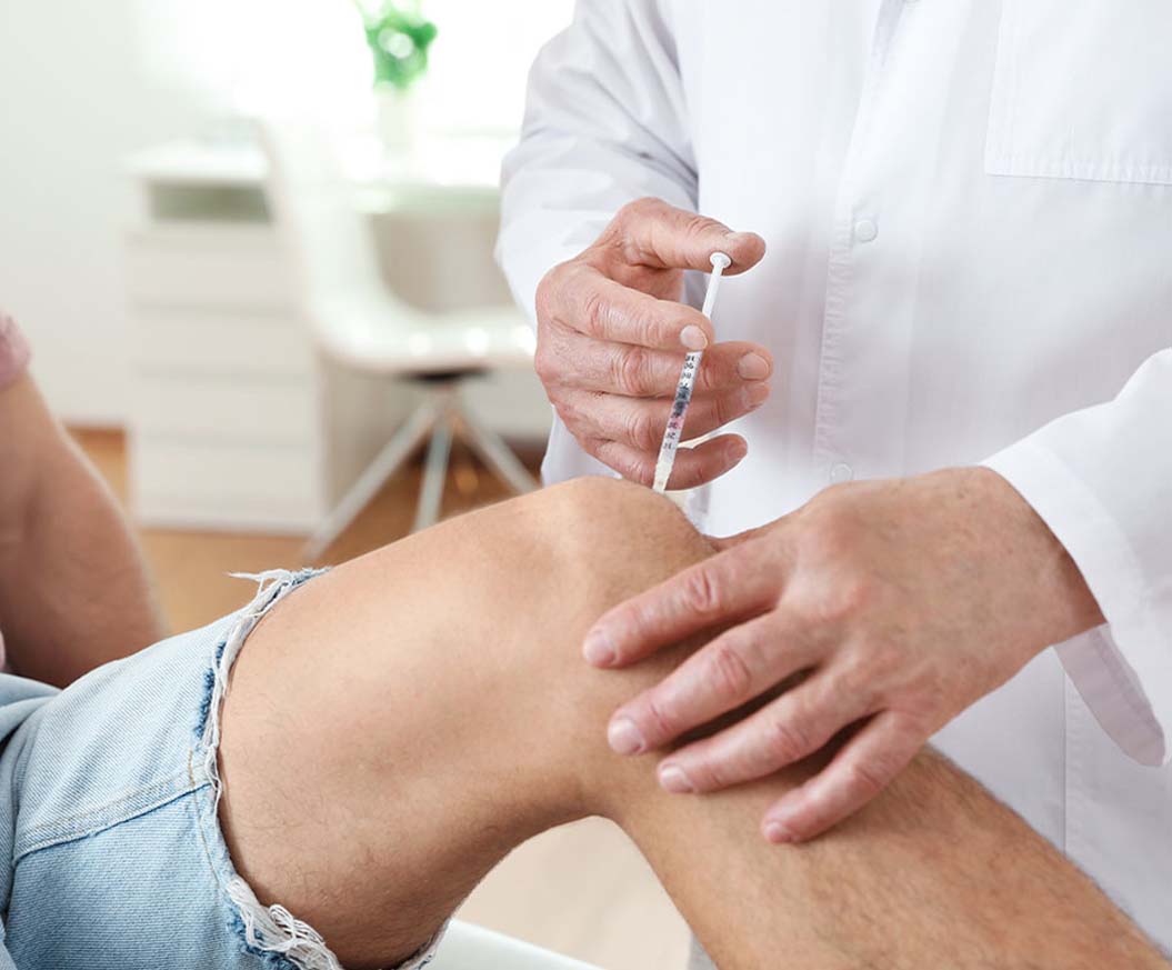 Doctor performing Advanced Joint Pain Relief injection on patient suffering with joint pain